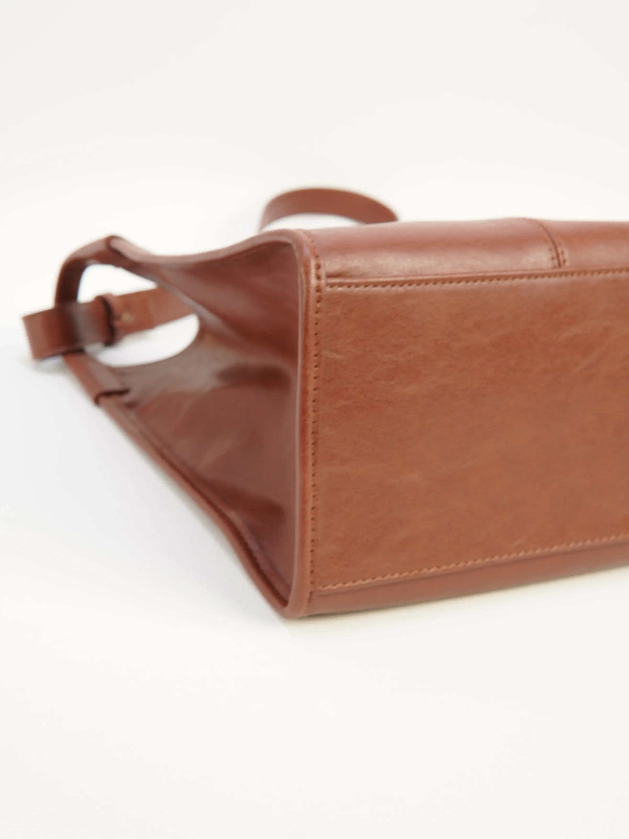 Mara cognac shoulder bag laid on its side showing the base panel