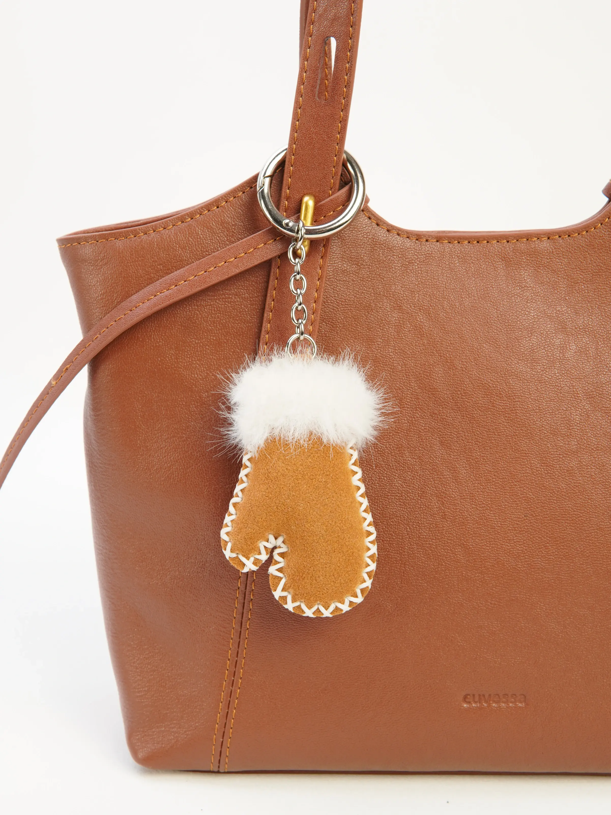 Milo Mitten Bag Charm photographed on a cognac tote bag